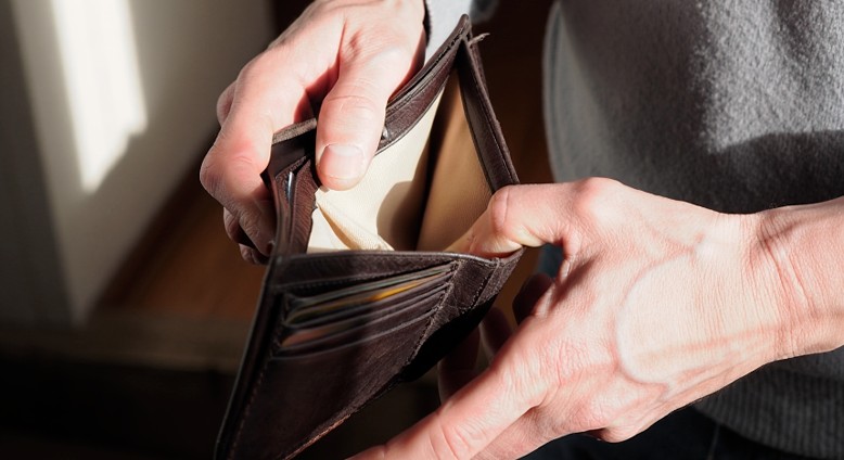 Мужчина держит в руках пустой кошелёк